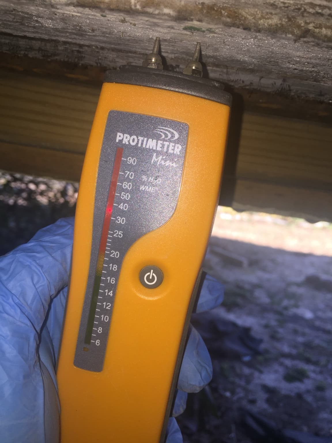 Moisture meter checking wood in a crawlspace